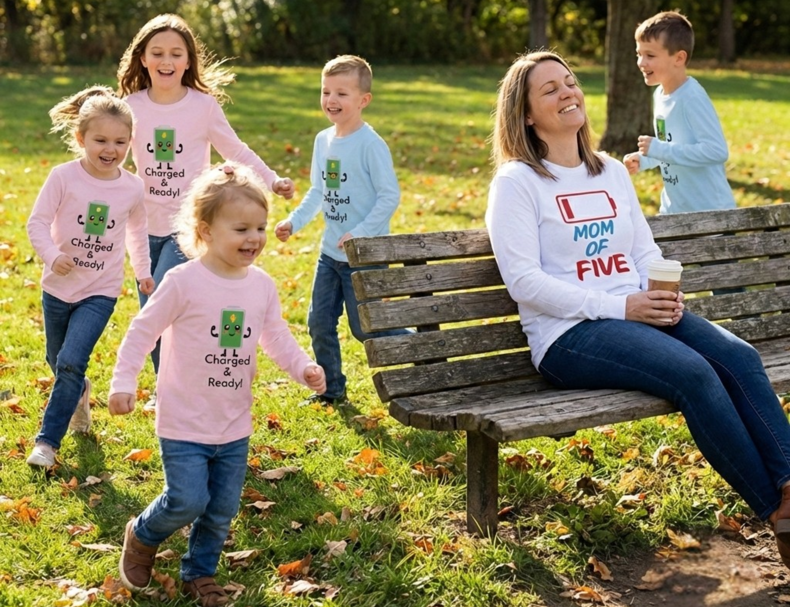 Woman sitting on a bench with children in a park, all wearing matching t-shirts.