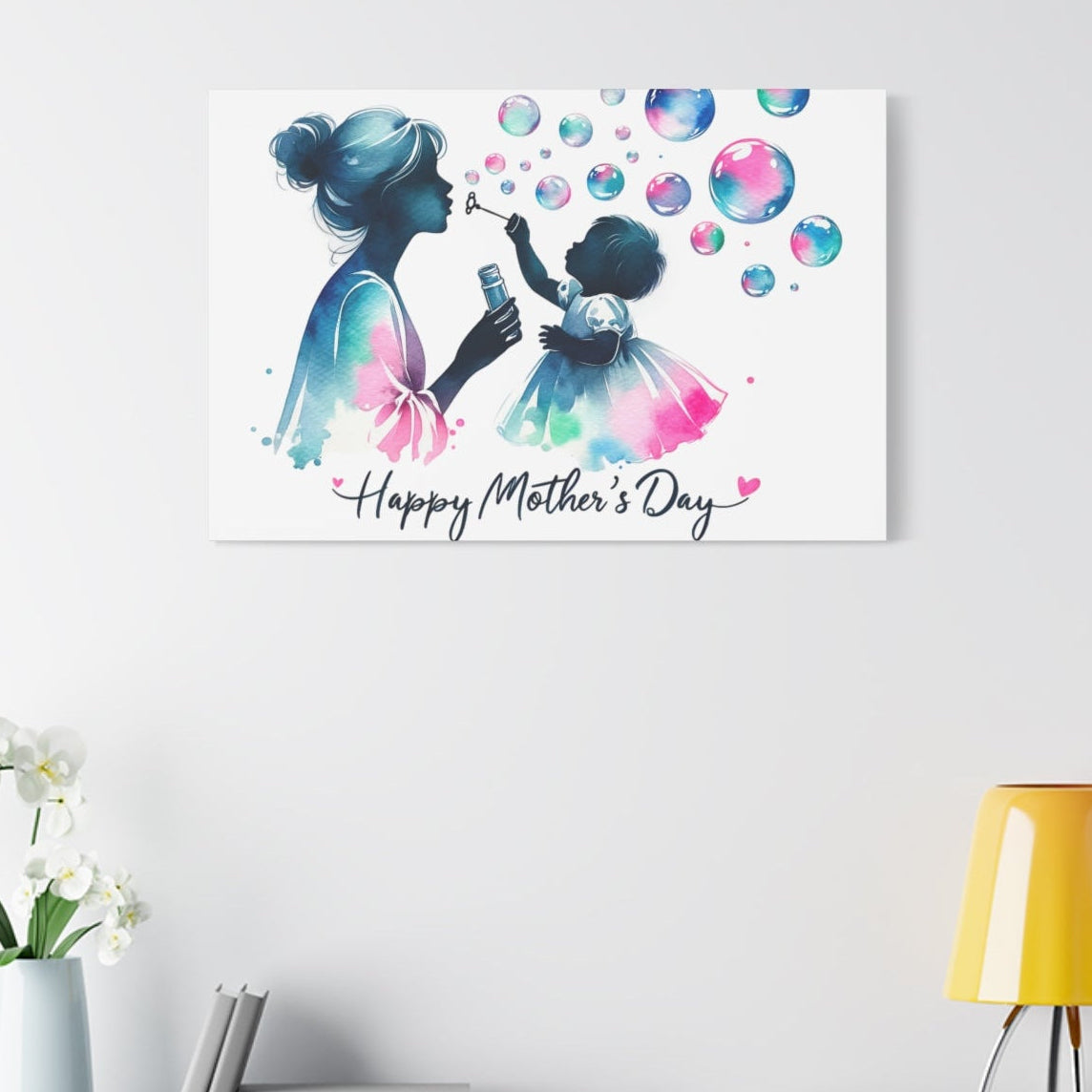Canvas print with a colorful illustration of a mother and child blowing bubbles, featuring 'Happy Mother's Day' text, on a wall above a shelf.