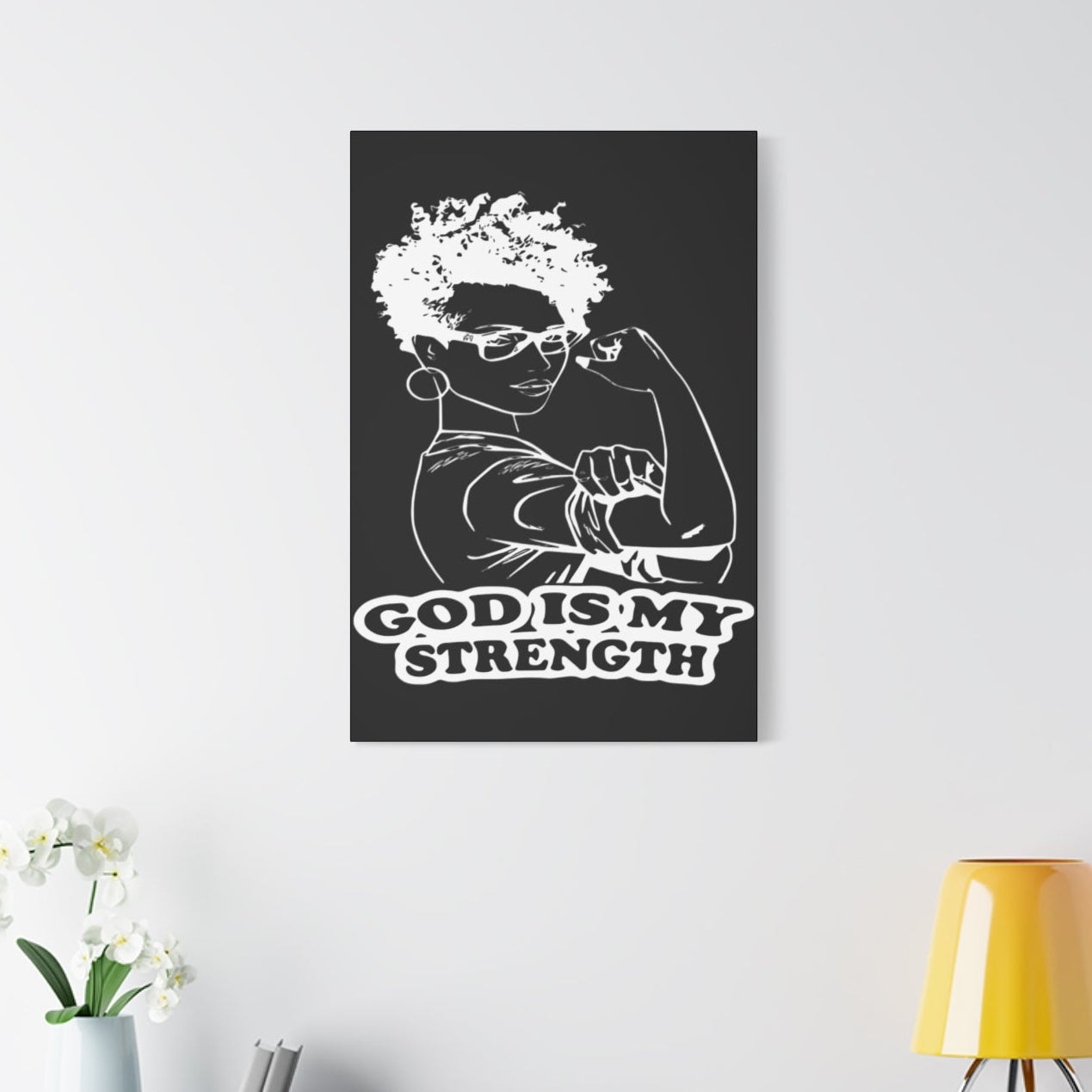 Poster with 'God is my strength' text on a wall above a white cabinet.